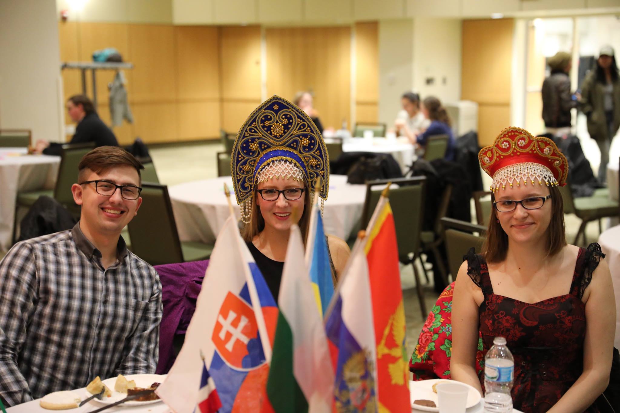 Three people sitting at a table with flags.