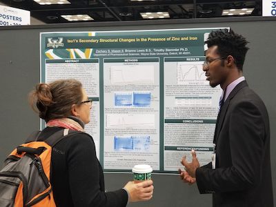 Wayne State student Zachary Mason, right, presents his research at the ABRCMS in 2018.