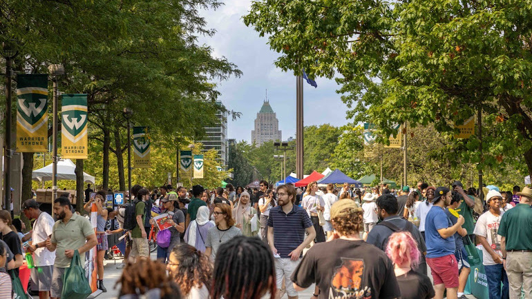 A large group of students and their families gather on Wayne State's campus.