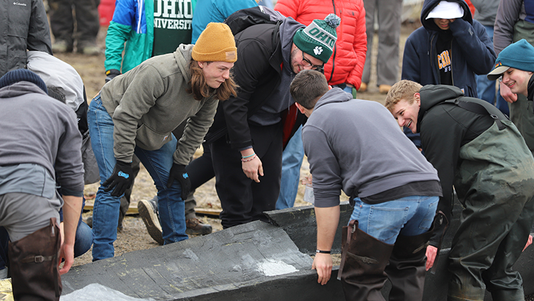 Engineering students from Ohio University survey the damage done to their concrete canoe following the buoyancy testing  at Lake St. Clair Metroparks.