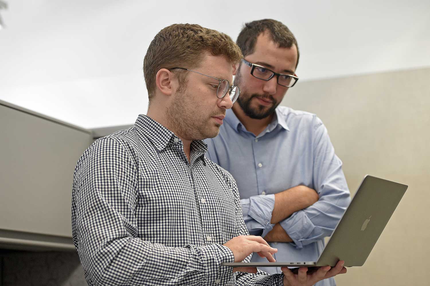Murat Yildirim and a Ph.D. student looking at data on a laptop