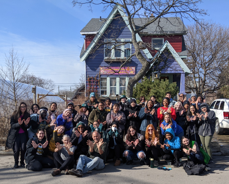 Students participating in Alternative Spring Break Detroit pose for a photo in front of Detroit Abloom.