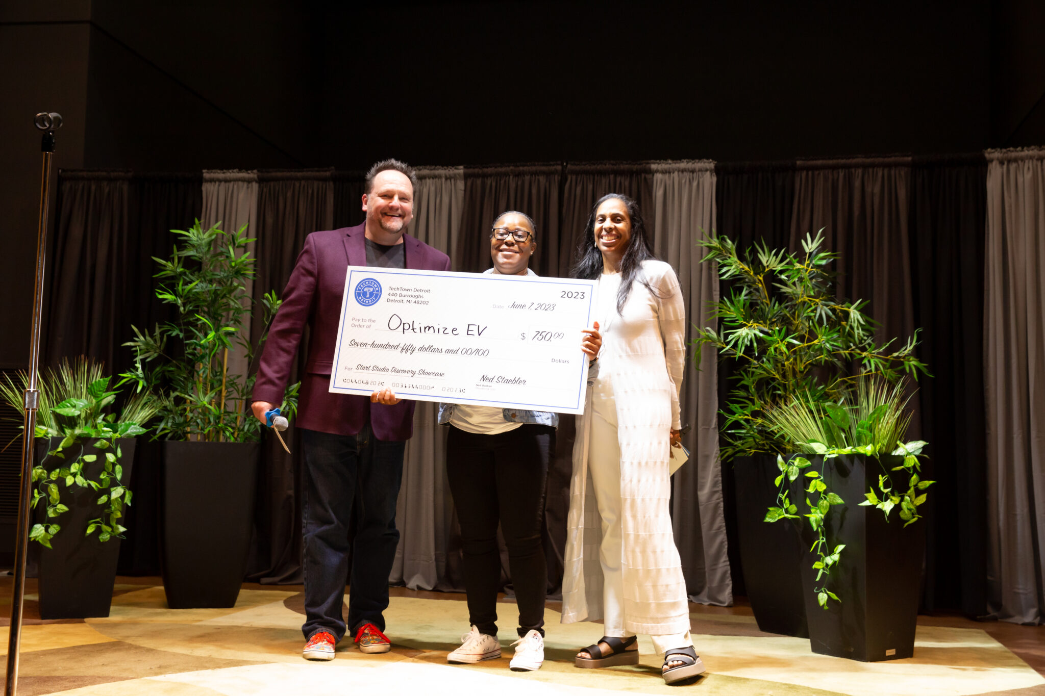 Brittany McGee (center), founder of OptimizeEV, stands next to Stefan Sysko (left), co-founder of Betterly AI and the MC for the event, and Dawn Batts, TechTown's director of growth capital.