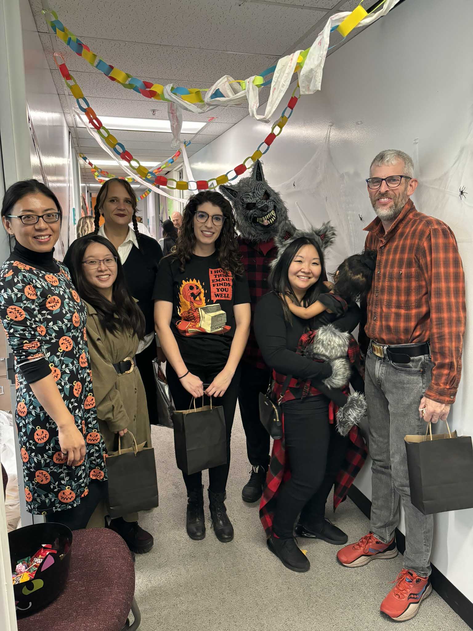 Students and faculty standing in front of Halloween decorations