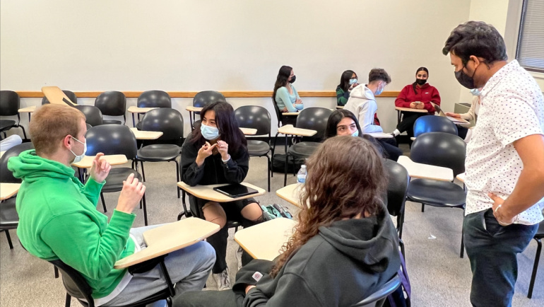 Peer mentor Deep Patel (standing, right) works with a small group of students in the Chemistry FIG to discuss how their degree will translate to employment.