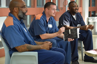 A group of incarcerated individuals sits in a gathering room, as part of the Wayne State University Inside Out Prison Exchange Program.