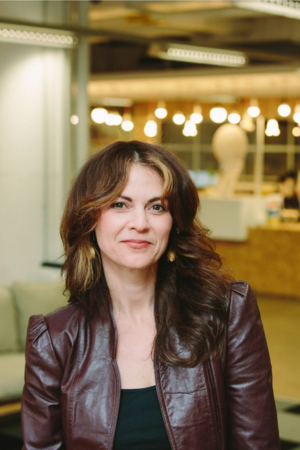 A headshot of a woman in a coworking space