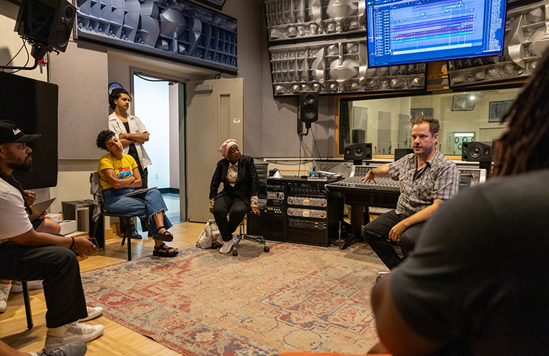 Ma Dukes, mother of legendary hip-hop producer J Dilla, listens as Wayne State University's Michael Shellabarger, assistant professor of music technology, speaks with the 2023 J Dilla Music Tech Teaching Workshop participants