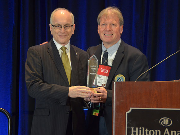 Sidney N. Dunn (left) receives the American Academy of Osteopathy's Academy Award from AAO President Michael P. Rowane.