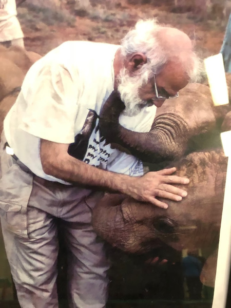 man hugging elephant