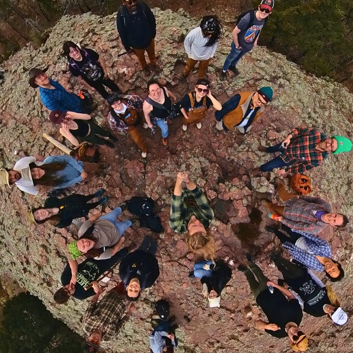 Students gathered in a dirt circle looking up