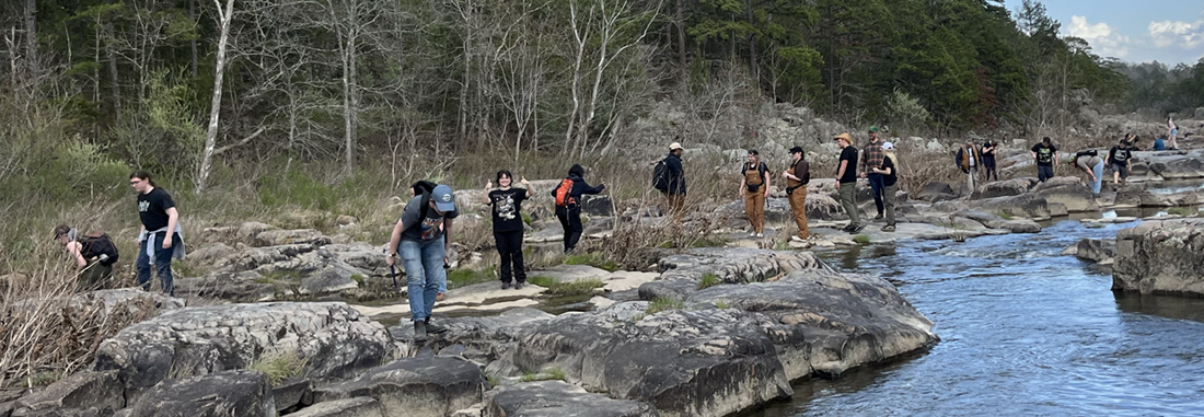 Students studying the rock layers near the water