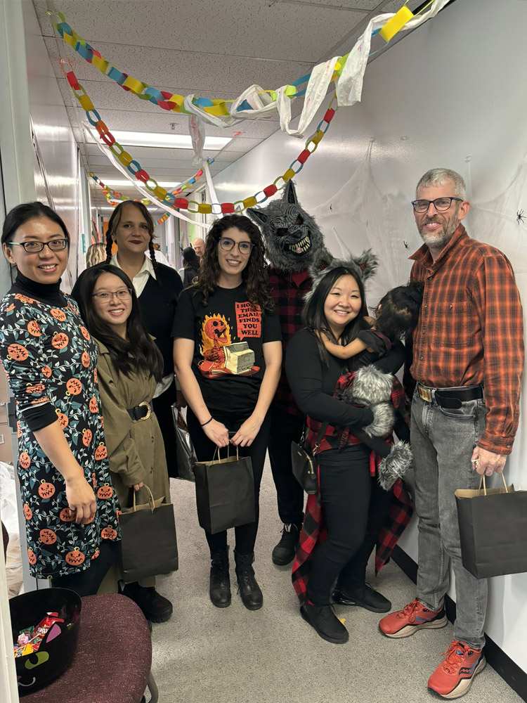 Faculty and staff standing with Halloween decorations