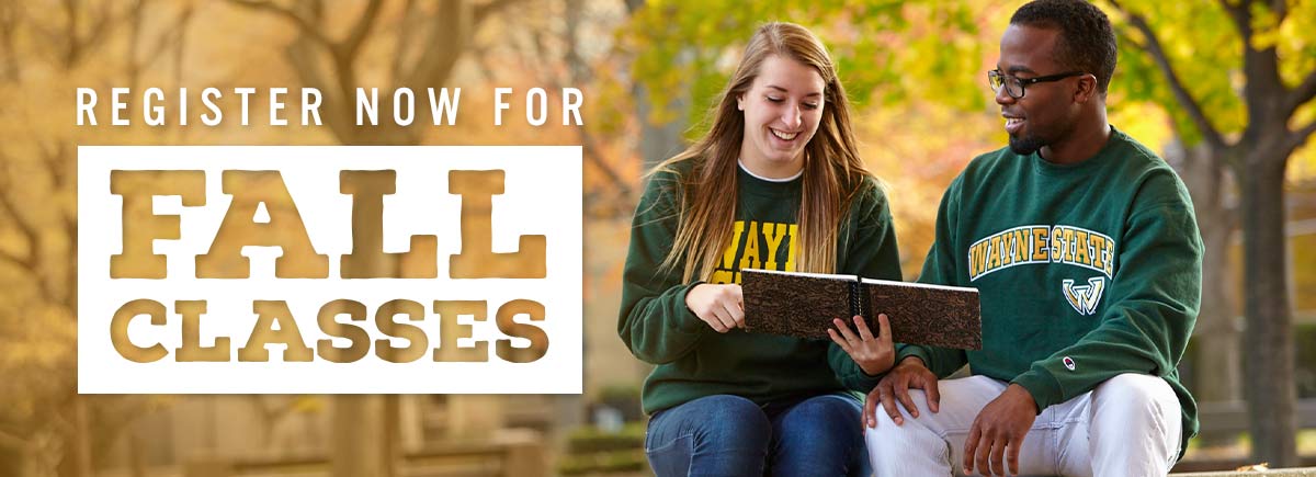 Two Wayne State University students sitting outside in the fall.
