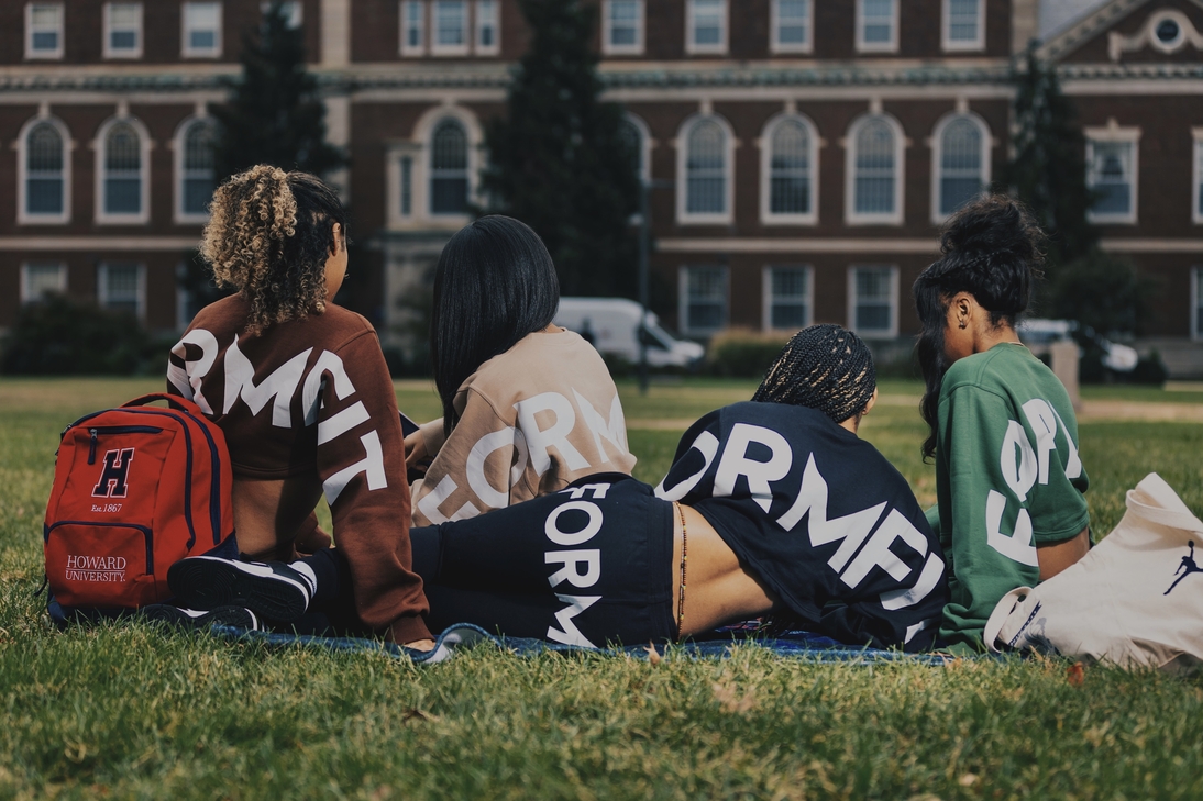 Four women sitting together on a blanket