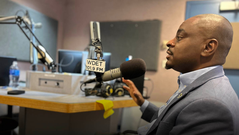 Vice Provost Darryl Gardner speaks into a studio microphone inside a radio station.