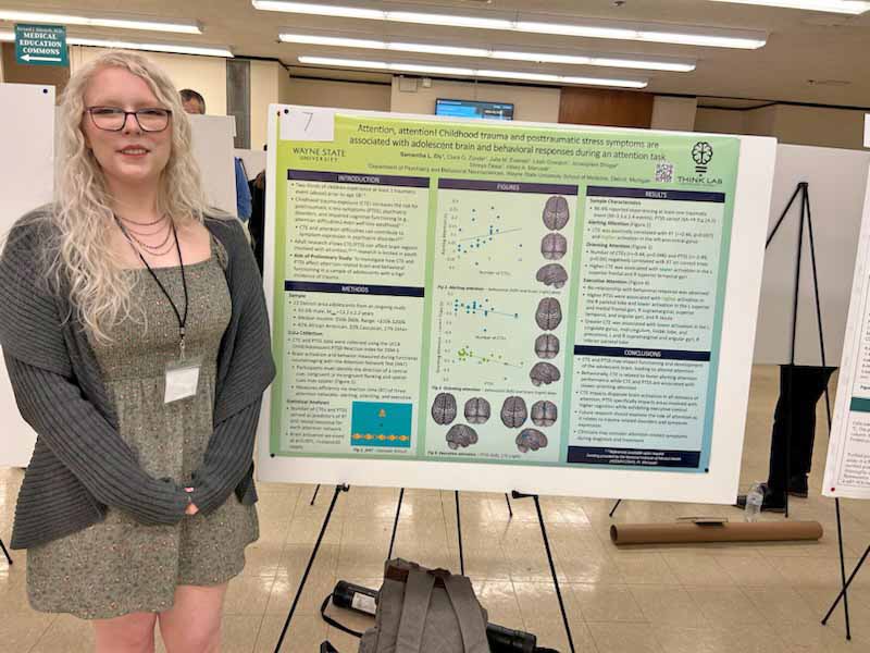 Wayne State graduate student presenting a research poster.