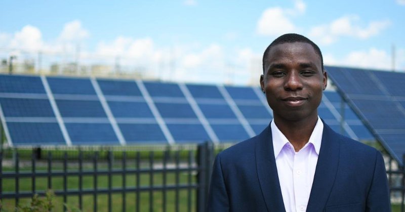 Habeeb Ayantayo standing in front of solar panels