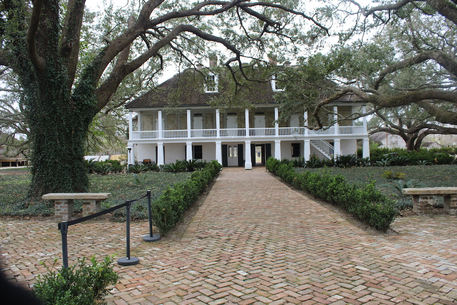 white plantation house covered in ivy