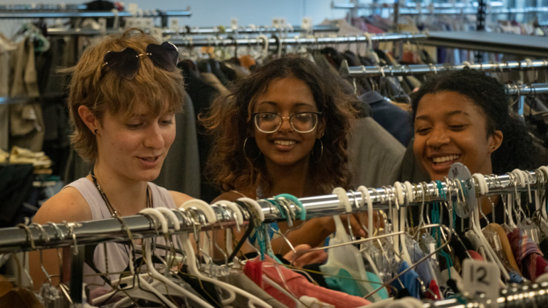 Wayne State students Blaise Richmond, Carmen Cook and Heera Thirukumaran look at clothes at The W Thrift Shop.