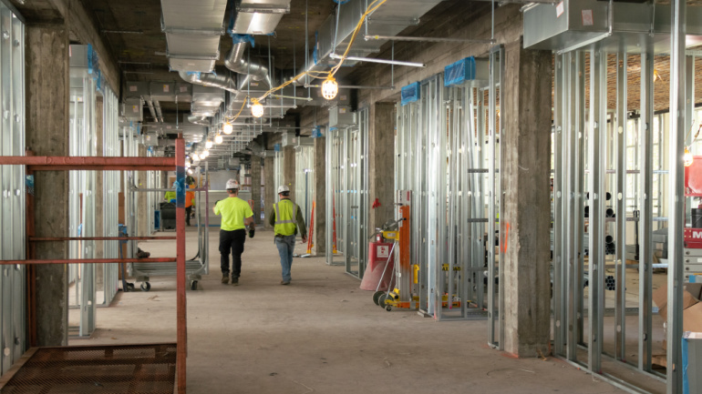 Workers walk through State Hall as it undergoes renovations. 