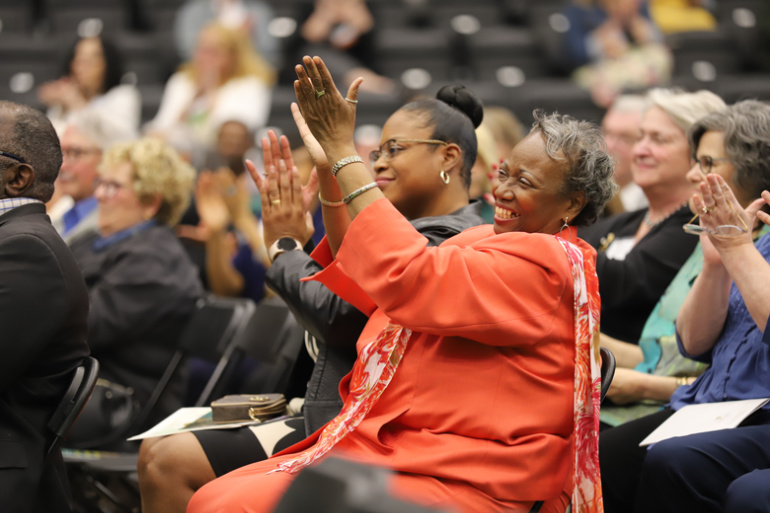 A member of the crowd claps during the Employee Recognition Ceremony at the Wayne State Fieldhouse.