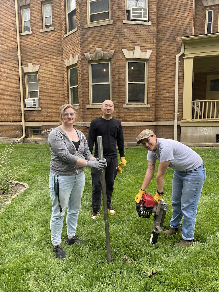 Students in center of picture wearing gloves are putting pipe into ground, which will help the sensor test for VOCs in groundwater