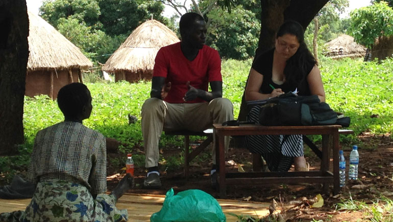 Jaymelee Kim (right) interviews a person in Uganda.