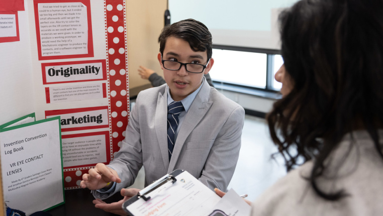 A young student presents at an invention competition.