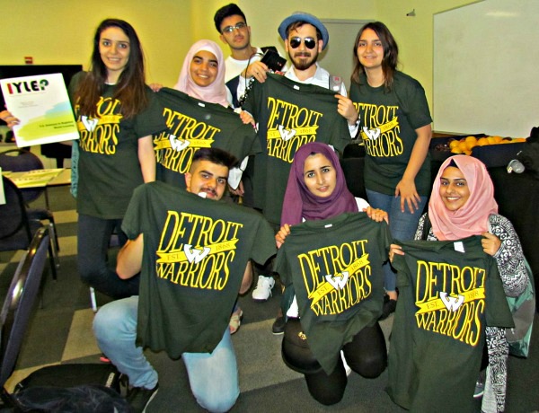 Iragi students holding shirts.