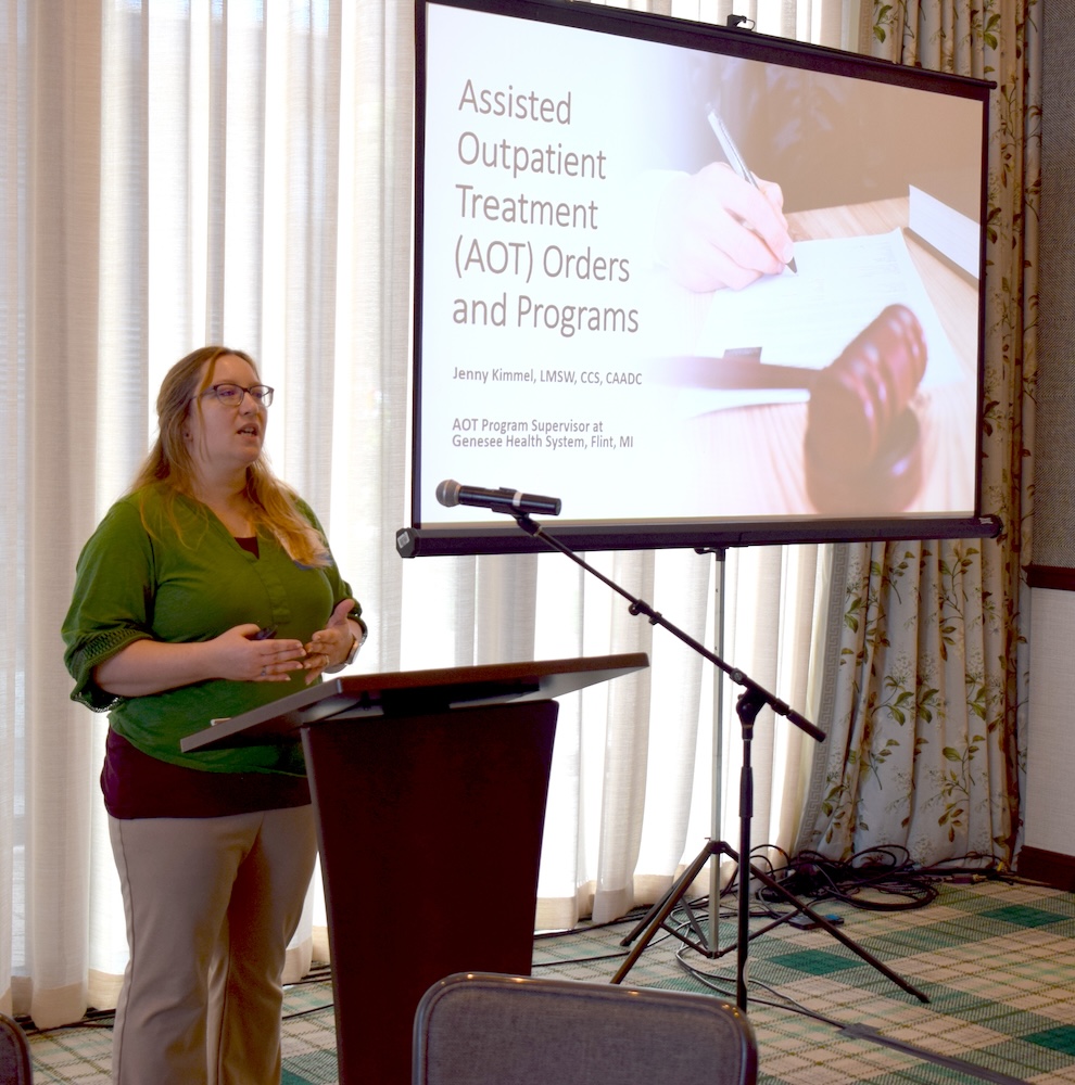 Kimmel presents at a podium at a professional conference.