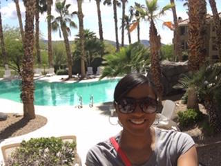 Jerea Jackson standing in front of a pool surrounded by trees.