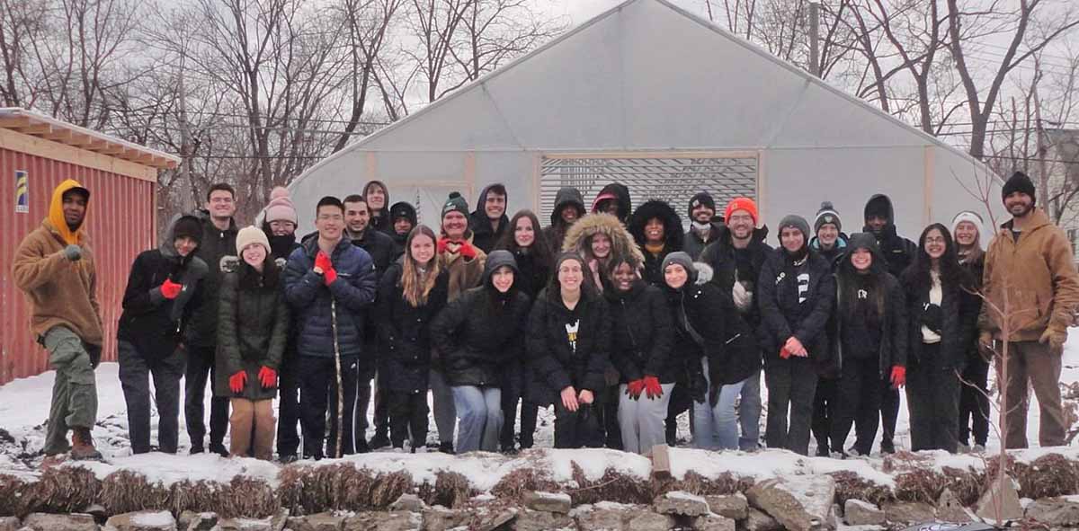 More than 30 Wayne State students, all participants of Alternative Spring Break 2023, stand outside.