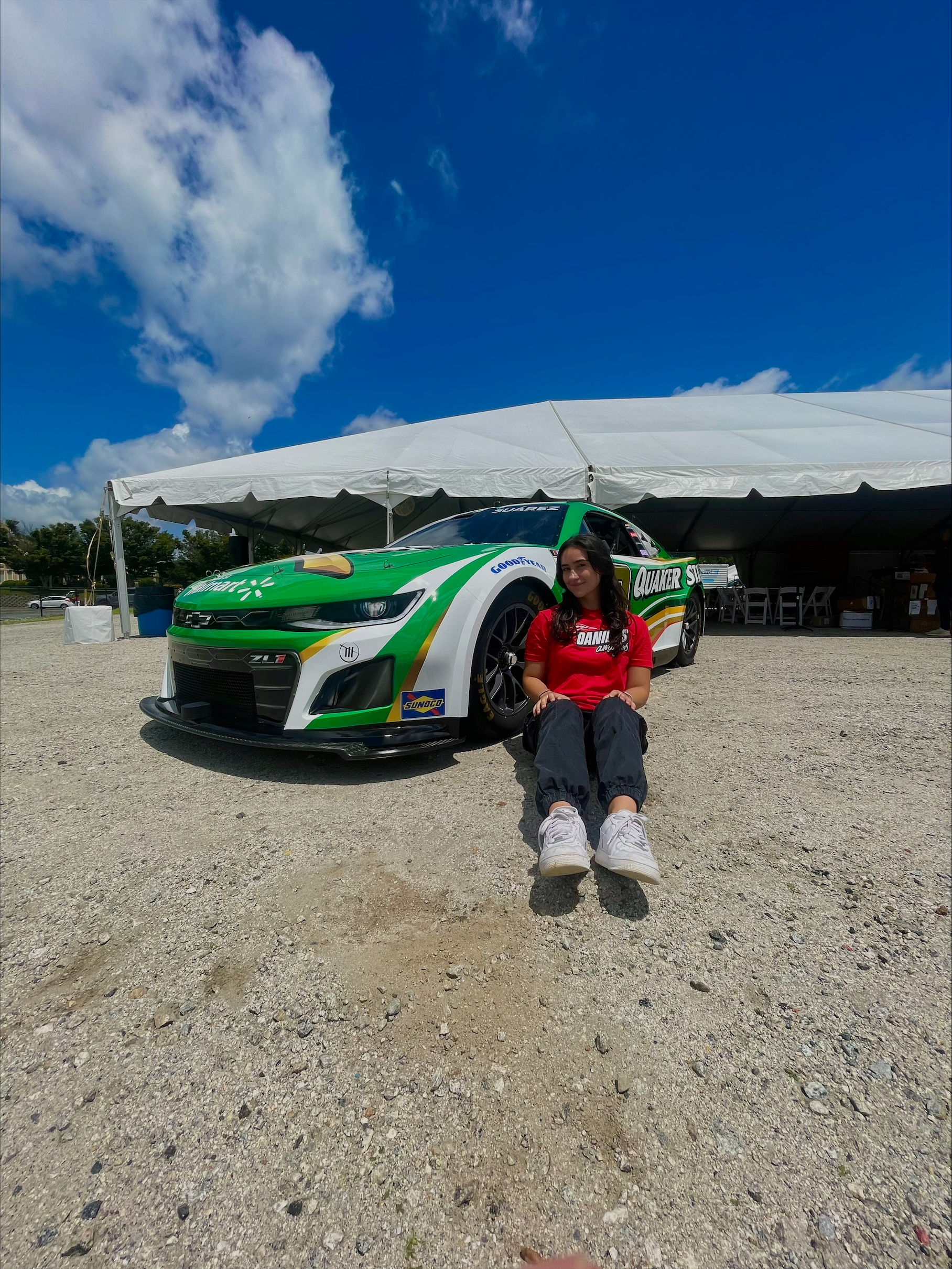 Woman seated in front of a racecar