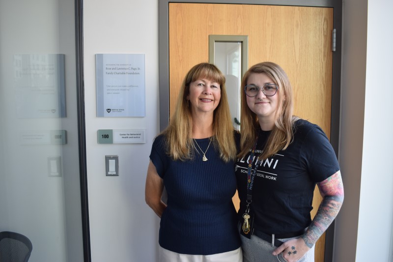 Page Foundation President Holly Kunick and Danielle Hicks pose with the plaque outside the CBHJ office