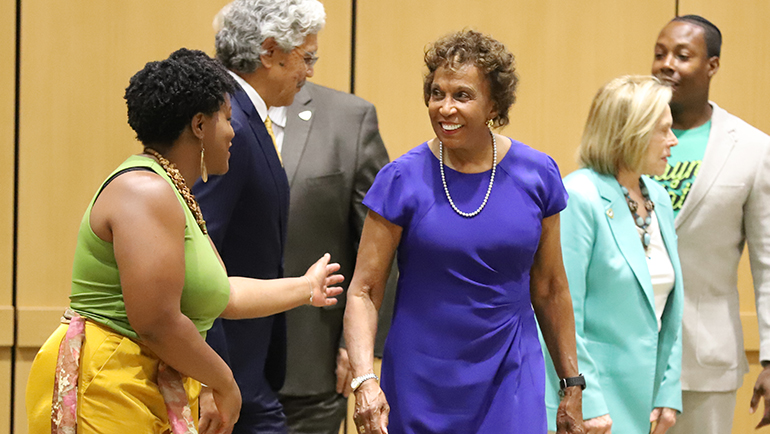 Former board member Denise Lewis receives congratulations at Thursday meeting from Danielle Atkinson, a current member of Wayne State's Board of Governors.