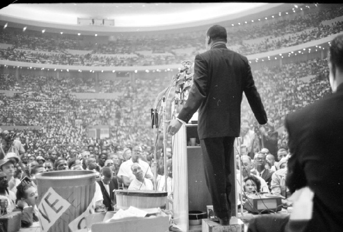 Martin Luther King standing at a podium in front of a stadium full of people