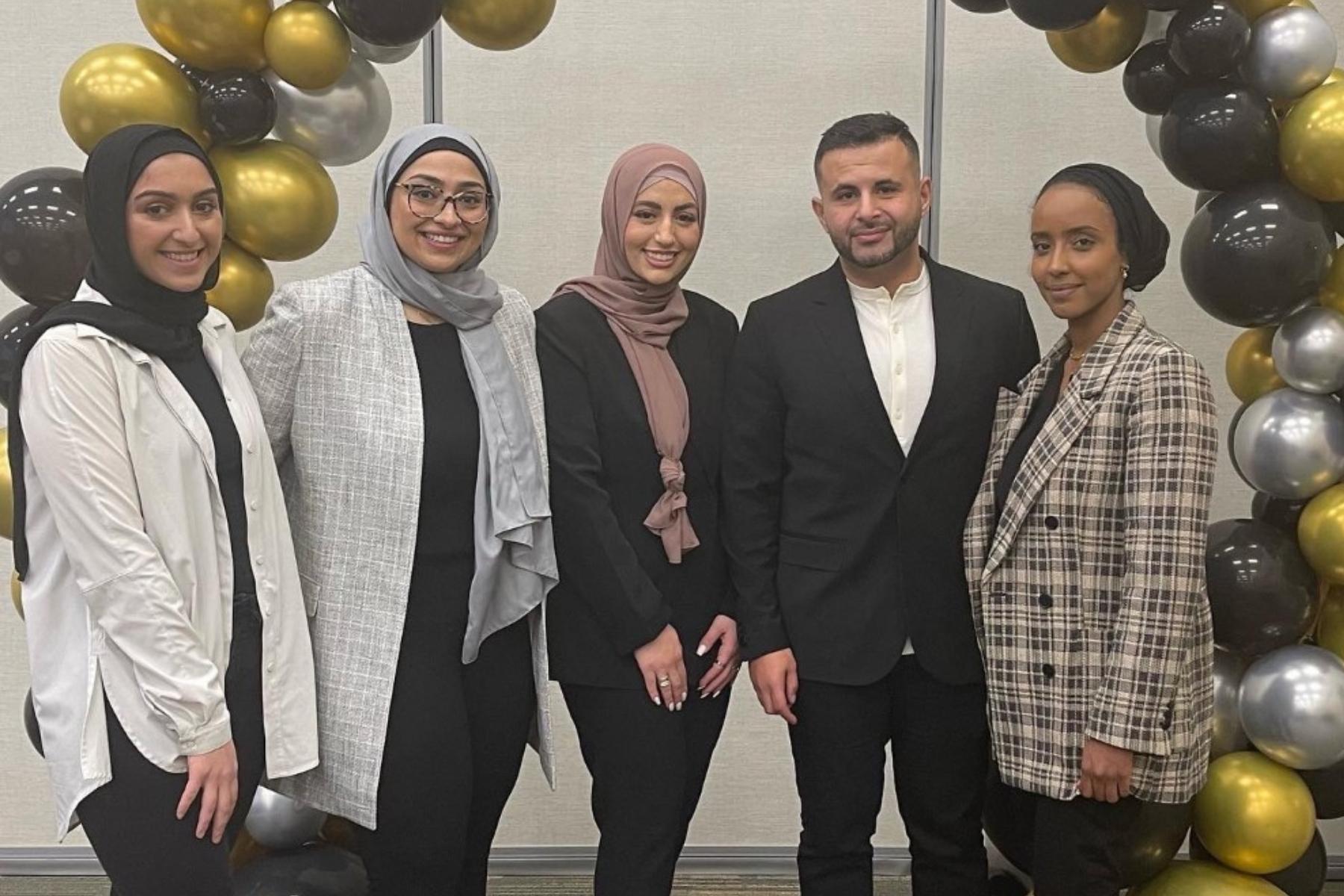 MLSA Iftar organizers pose for a photo in front of a balloon arch