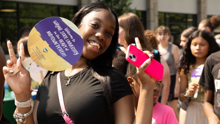 A smiling student enters campus