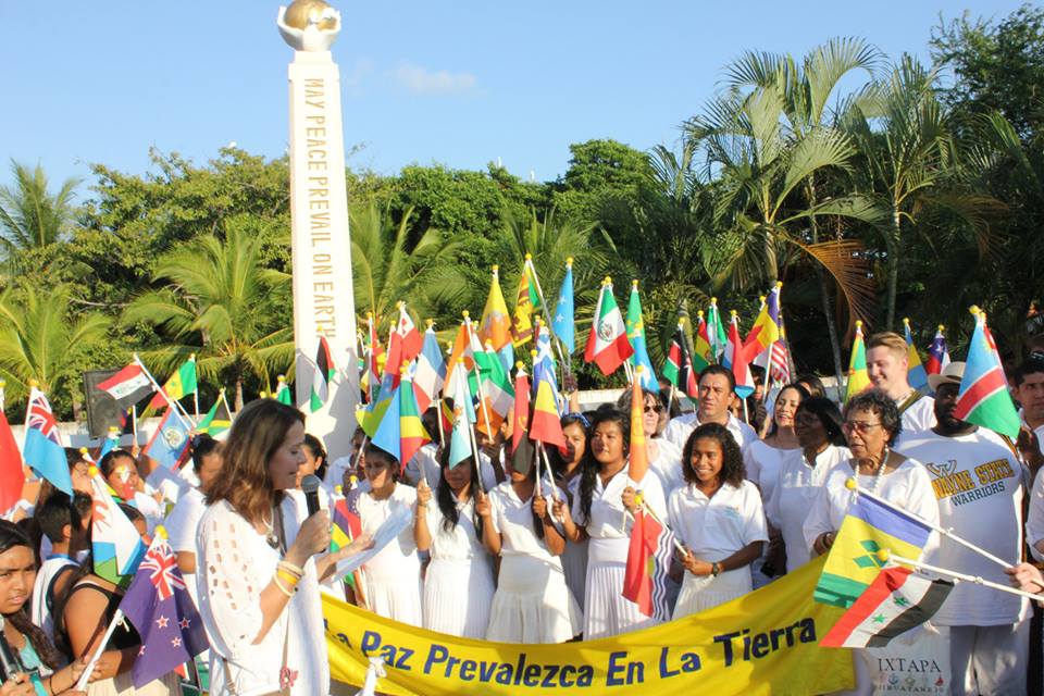 A crowd holds up flags celebrating peace