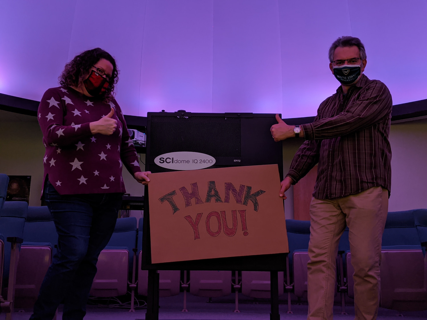 Planetarium director Megan McCullen and Peter Hoffmann with a thank you sign