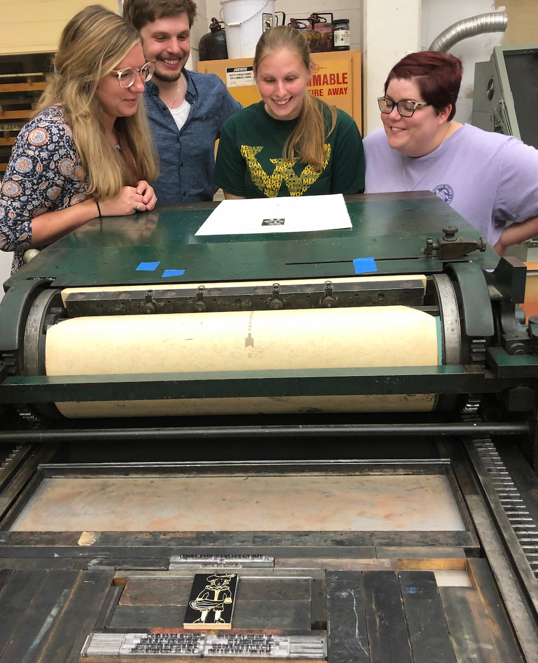Students in Professor Chess' ENG 8002 class overlooking their work on the Vandercook Press