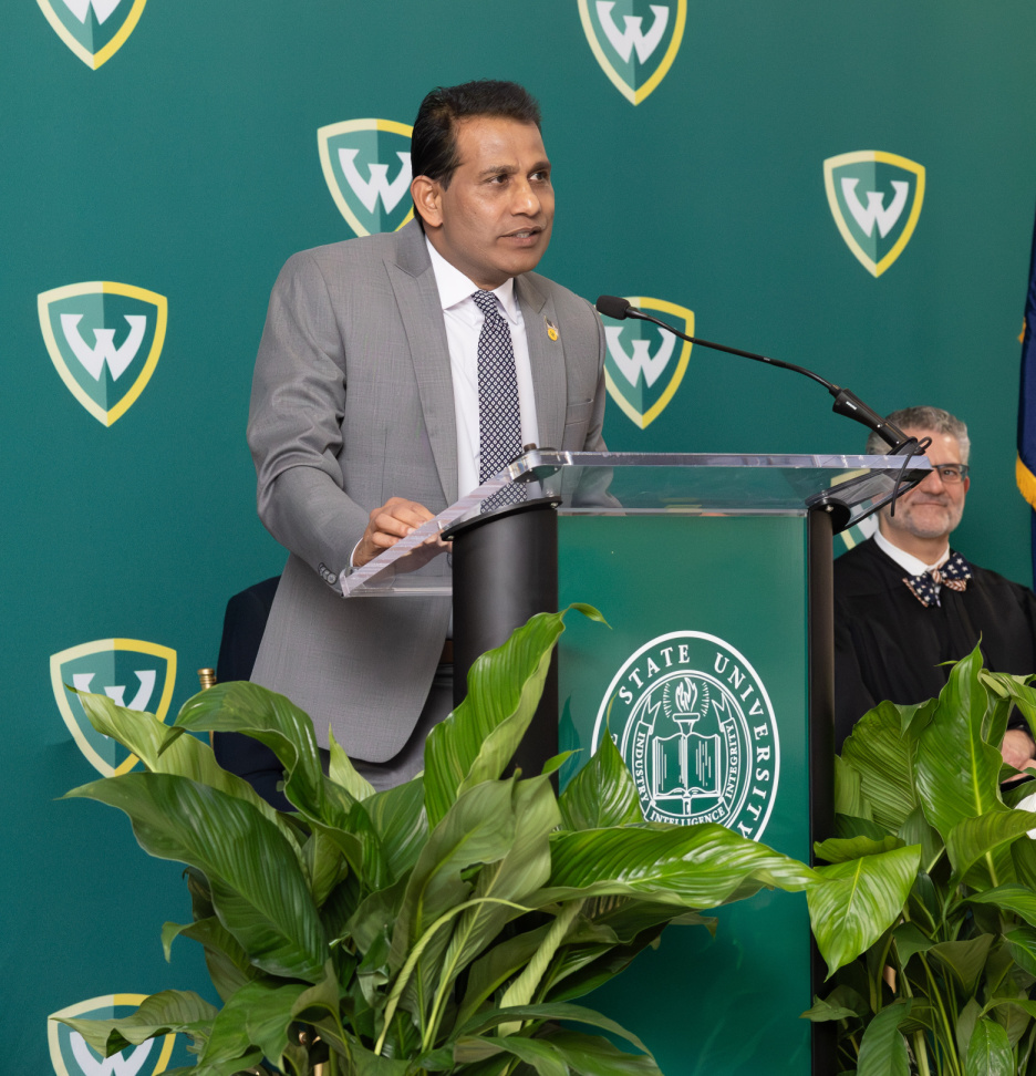 Governor Sunny Reddy speaks at a podium at the Wayne State University Board of Governors swearing in ceremony.