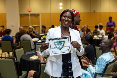 Dr. Rebecca Sikanyani Furaha holds her Paper Plate Award