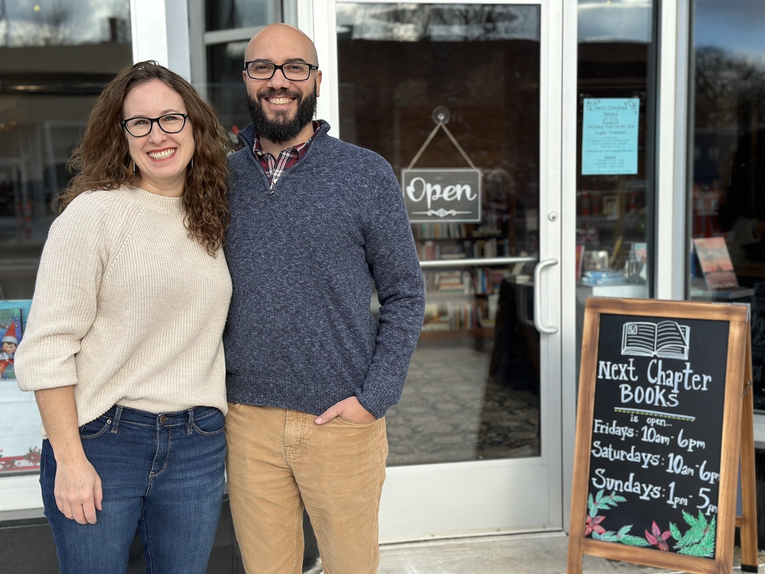 man and woman stand in front of Next Chapter Books storefront