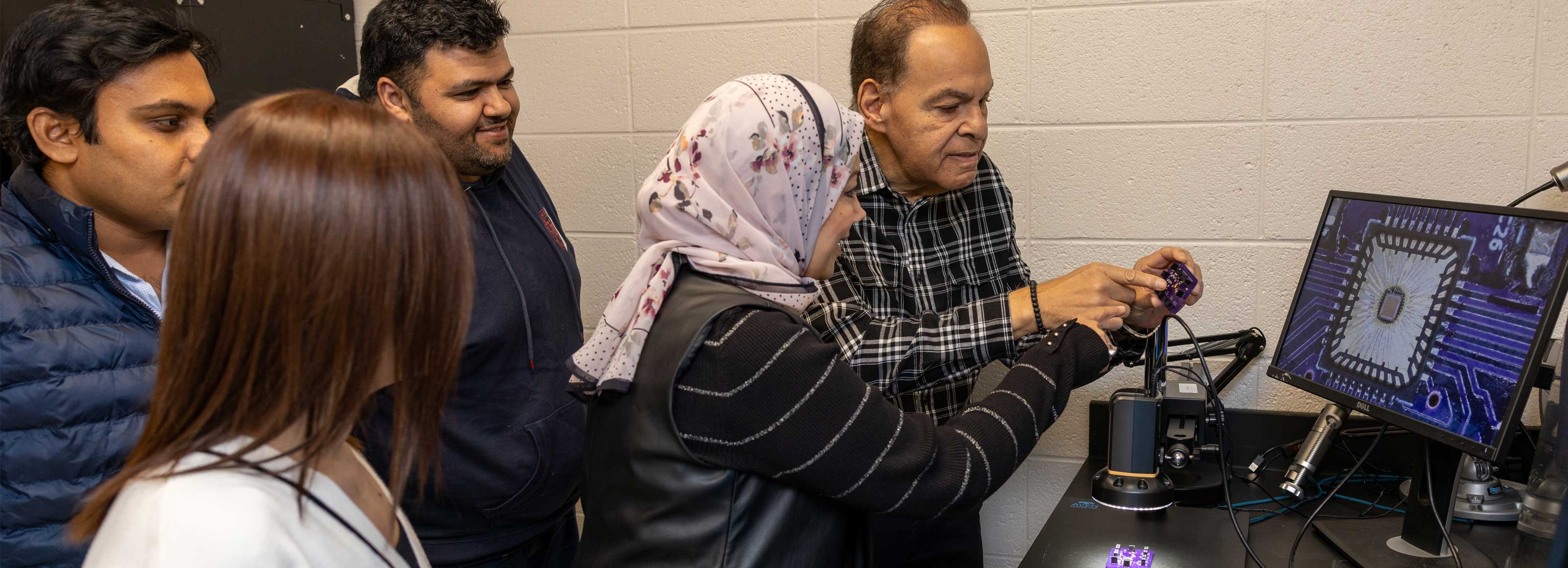 Professor Mohammed Ismail working with students in the semiconductor fabrication lab