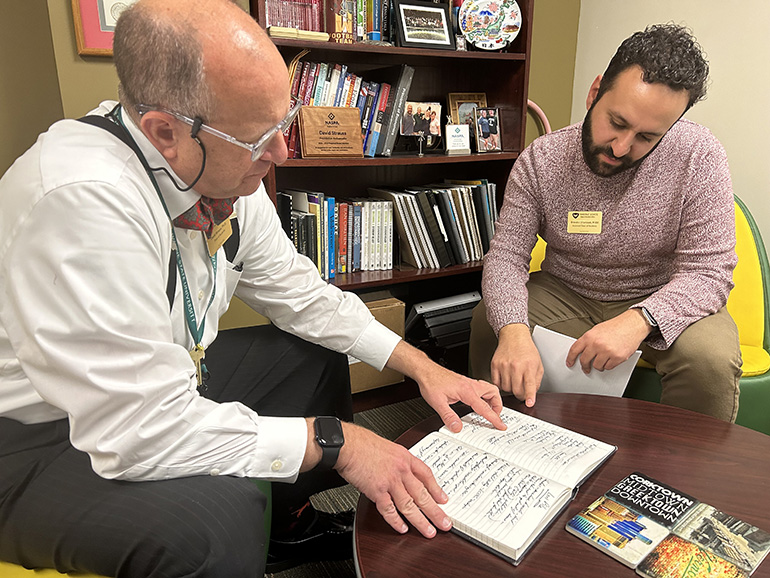 Dean of Students David Strauss, who wrote a letter of recommendation to the governor on behalf of Shamoun, goes over notes with him in the Dean of Students Office.