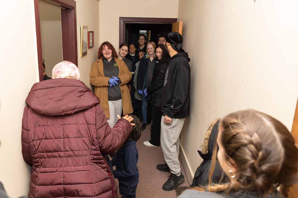 Wayne State students gather in a hallway, chatting and laughing. 