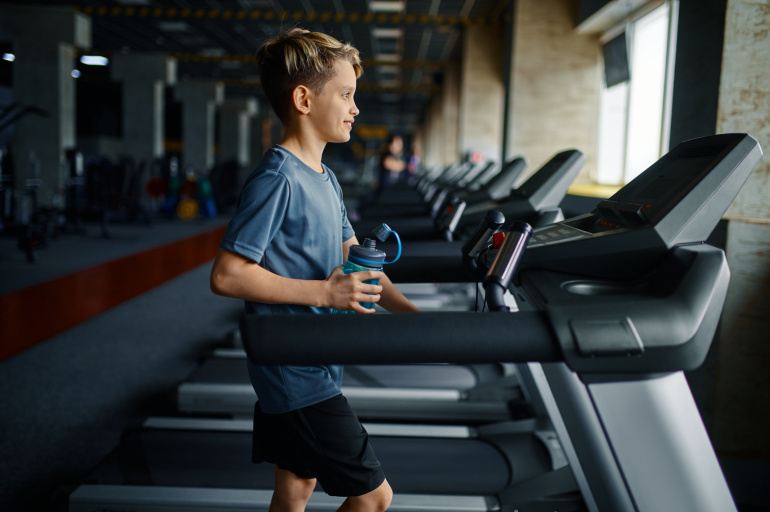 A young man runs on the treadmill.