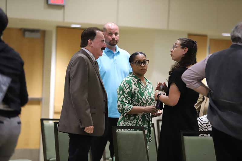 Simone Chess speaking with Provost Kornbluh at the Wayne State University Board of Governors meeting.
